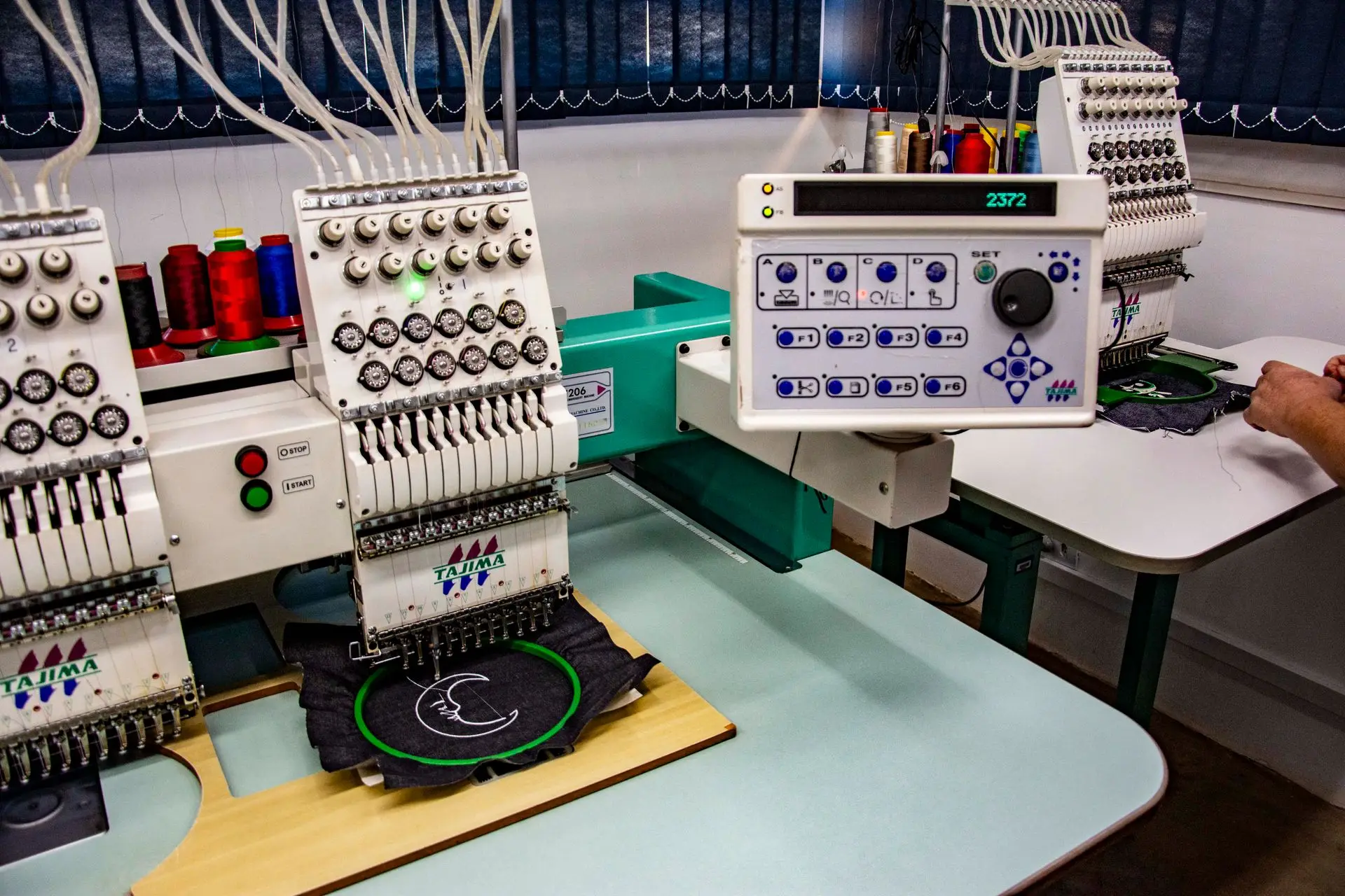 Multi-head embroidery machine stitching a logo